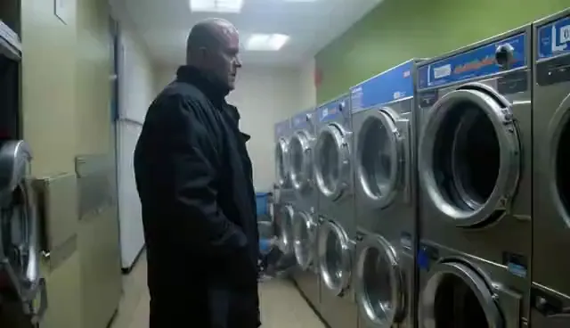 Video preview: Noir detective — An adult male detective in a dark coat examines a quiet laundromat, moody lighting and a subtle supernatural atmosphere.
